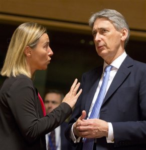 British Foreign Minister Philip Hammond, right, speaks with Italian Foreign Minister Federica Mogherini during a round table meeting of EU foreign ministers in Luxembourg on Monday, Oct. 20, 2014. European Union nations are working to find funds to help fight Ebola in West Africa and streamline a common approach in dealing with the health crisis. (AP Photo/Virginia Mayo)