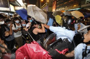 Protesters scuffle with riot police in the occupied area in the Mong Kok district of Hong Kong, late Friday, Oct. 17, 2014. New scuffles broke out Friday night between Hong Kong riot police and pro-democracy activists in a district where police cleared protesters earlier in the day. The chaotic scenes unfolded hours after police moved in to clear tents, canopies and barricades at Mong Kok, a smaller protest zone across Victoria Harbor from the main occupied area in the heart of the financial district. (AP Photo/Kin Cheung)