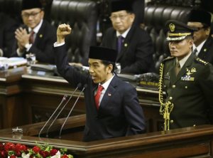 Indonesian President Joko Widodo, center, shouts "freedom" while raising his fist as he delivers his speech during his inauguration ceremony as the country's seventh president at the parliament building in Jakarta, Indonesia, Monday, Oct. 20, 2014.  (AP Photo/Dita Alangkara)