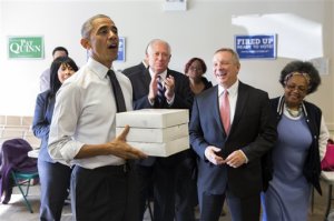 Gov. Pat Quinn, D-Ill., center, and Sen. Dick Durbin, D-Ill., second from right, watch as President Barack Obama delivers doughnuts and pastries to Democratic campaign volunteers on Monday, Oct. 20, 2014, in Chicago. Obama is in Chicago campaigning for Gov. Pat Quinn, D-Ill. (AP Photo/Evan Vucci)