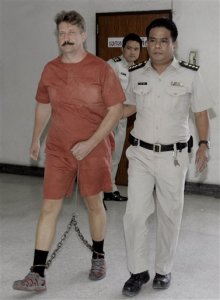 Alleged Russian arms dealer Viktor Bout, left, is led to the court room by prison officials at criminal court in Bangkok, Thailand Monday, Sept. 22, 2008. Bout's extradition hearing to the United States started Monday, after a string of delays in the high-profile case because of complications with his defense team in Thailand. Bout, dubbed "The Merchant of Death," has been indicted in the U.S. on four terrorism charges. He was arrested in Thailand on March 6. (AP Photo/Apichart Weerawong)