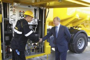 Russia's President Vladimir Putin (R) shakes hands with an employee as he visits a fuel filling complex operated by Rosneft, the state-owned oil company.