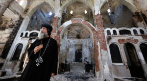 Bishop-General Macarius, a Coptic Orthodox leader, walks around the burnt and damaged Evangelical Church in Minya governorate, about 152 miles south of Cairo. (Reuters/Louafi Larbi) 