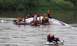 Rescue personnel work to free passengers from a TransAsia ATR 72-600 turboprop plane that crash-landed into a river outside Taiwan's capital Taipei in New Taipei City on Feb 4, 2015.