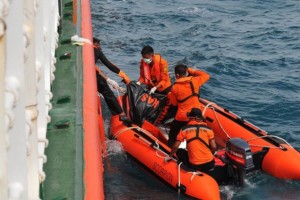 Indonesian rescue personnel from the National Search and Rescue Agency recover a body from the underwater wreckage of the ill-fated Air Asia flight QZ8501 in Java sea