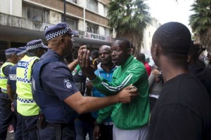 Police urge a group of foreign nationals to head home after a peace march in the South African port city of Durban