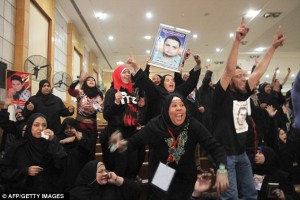   Relatives of those killed in the violence last February cheer the decision in a court room in Cairo 