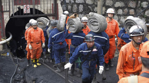 Rescuers carry hoses into the flooded shaft at the Xiahaizi Coal Mine in Qujing city, southwest Chinas Yunnan province.