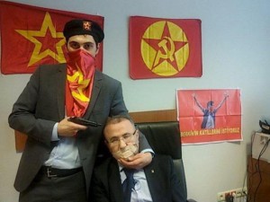 A gunman poses with Prosecutor Mehmet Selim Kiraz with a gun on his head after being taken hostage in his office in a court house in Istanbul March 31, 2015.    