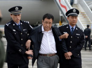 Chinese police escort Li Huabo (centre) upon his arrival at the Beijing Capital International Airport yesterday