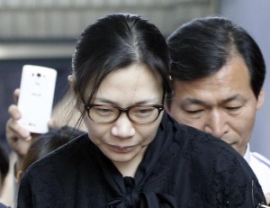 Former Korean Air executive Cho Hyun-ah, center, leaves the Seoul High Court in Seoul, South Korea, Friday, May 22, 2015. The upper court Friday sentenced Cho to 10 months in prison and then suspended the sentence for two years.