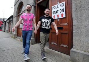 A couple pose holding hands as they walk out of a polling station after voting in Drogheda, north of Dublin on May 22, 2015 