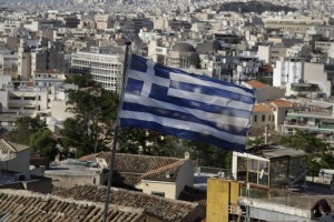A Greek national flag flies in the city of Athens, Friday, May 8, 2015. Greece's prime minister Alexis Tsipras said Friday he is optimistic his cash-strapped country will soon reach an agreement with its international creditors, averting a potential default. 