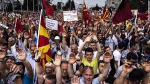 People wave Macedonian flags and raise their hands during an anti-government protest in downtown Skopje on May 17.