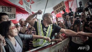 A pro-Beijing protester tries to punch a pro-democracy demonstrator after a heated argument outside the government building in Hong Kong in April 2015. 