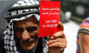A Palestinian man holds a red card calling for the suspension of Israel’s membership in Fifa and say no to racism, during a rally in support of the Palestinian Football Association in the West Bank town of Ramallah on 28 May. 