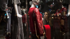 A woman is seen through the window of a store as she looks at dresses for sale in Rio de Janeiro, Brazil. Friday, June 12, 2015 Brazil’s top credit information bureaus estimate that as of April, more than 55 million Brazilians were behind on paying off credit cards or loans. That’s 37 percent of the adult population in a country of about 200 million people, and the numbers are rising