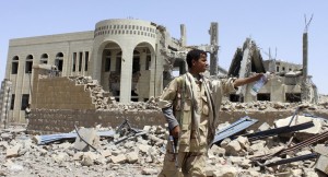 Houthi militant stand infront of a court building, whiuch was damaged in a Saudi led air strike in Saada May 31 2015