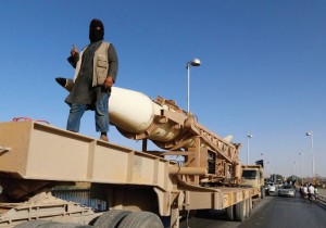 AN ISIS member rides on a rocket launcher in Raqqa in Syria two months ago