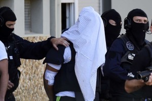 French police escort Yassin Salhi as they leave his flat in Saint-Priest.
