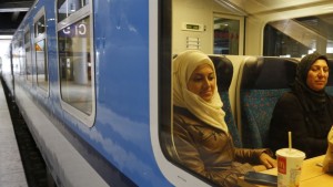 Reem Habashieh and her mother Khawla Kareem sit in a train in Berlin that brings them to Dresden from where they continued their journey to Chemnitz on Sept. 16, 2015. On Tuesday afternoon, the family _44-year-old Khawla Kareem, her daughters Reem, 19, and Raghad, 11, and sons Mohammed, 17, and Yaman, 15 finally got their papers, all stamped, with passport photos, a new address and train tickets to go to Chemnitz, a city of 240,000 near the Czech border. 