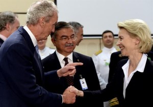Spain's Defence Minister Pedro Morenes Eulate (L) shakes hands with his German counterpart Ursula von der Leyen (R) as thier Turkish counterpart İsmet Yılmaz (C) looks on prior to the start of a NATO Defence meeting at the NATO headquarter in Brussels on June 24, 2015. 