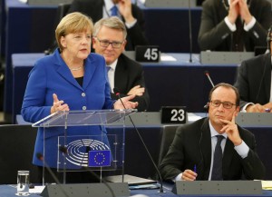 German Chancellor Angela Merkel gestures as she delivers her speech as part of a joint appearance with French President Francois Hollande, right, at the European Parliament in Strasbourg, eastern France, Wednesday, Oct. 7, 2015. Angela Merkel and Francois Hollande are making a historic appeal to the European Parliament on Wednesday. 