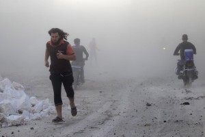 Residents run though dust in a site damaged by what activists said were airstrikes carried out by the Russian air force in the rebel-controlled area of Maaret al-Numan town in Idlib province, Syria on Oct. 24, 2015.