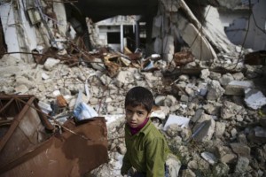 A boy walks amid damaged buildings in the town of Douma, eastern Ghouta in Damascus, Syria October 26, 2015. 