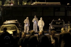 Forensic experts search for evidence on a street where a bomb exploded outside the entrance of the Hellenic Business Federation offices in Athens, Greece, November 24, 2015. 