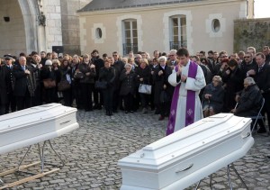 A priest blesses the coffins of two sisters, Marion and Anna Petard, in Blois, central France, Monday, Nov. 23, 2015. The two sisters were killed while having dinner in a sidewalk cafe, in the attacks in Paris on Nov. 13, the deadliest since WWII. 