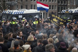 A flag reads "Islamists Not Welcome" as mounted Dutch riot police separates pro and anti Pegida demonstrators during a rally against islamisation in Amsterdam, Netherlands, Saturday, Feb. 6, 2016.