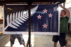 Factory workers Garth Price (R) and Andrew Smith hang new designs of the national flag of New Zealand at a factory in Auckland, New Zealand, in this November 24, 2015