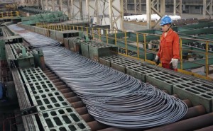 A labourer looks at steel coils next to a production line of Dongbei Special Steel Group Co., Ltd., in Dalian, Liaoning province.
