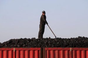 A worker speaks as he loads coal on a truck at a depot near a coal mine from the state-owned Longmay Group on the outskirts of Jixi, in Heilongjiang province, China.