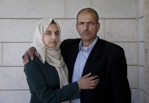 Ismail al-Wawi, 54, right and Ghayda al-Wawi, 17, the father and the sister of 12 year old Palestinian girl imprisoned by Israel for allegedly attempting to carry out a stabbing attack in a West Bank settlement, pose for a photo at the family house in the West Bank village of Halhoul, Hebron, Monday, April 11, 2016.
