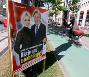 A cyclist drives past an election poster of businessman Richard Lugner with his wife Cathy Lugner, independent candidate for presidential elections, in Vienna, Austria. Wednesday, April 20, 2016.