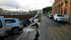 Parked cars are seen in a chasm after a road running next to the River Arno collapsed, in Florence, Italy in this May 25, 2016.