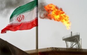 File-A gas flare on an oil production platform in the Soroush oil fields is seen alongside an Iranian flag in the Gulf.