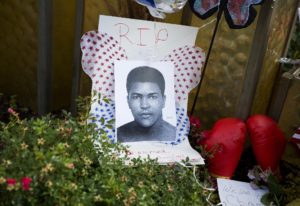 An image of Muhammad Ali and boxing gloves are left at a makeshift memorial to Ali at the Muhammad Ali Center, Monday, June 6, 2016, in Louisville, Ky. The president of Turkey and king of Jordan joined the long line of world leaders, religious figures and superstars set to speak at Ali's funeral Friday. 