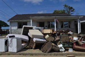 Water damaged furniture, appliances and other home furnishings line the sidewalk of a home in Rainelle, W.Va., Sunday, June 26, 2016.