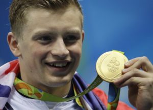 Britain's Adam Peaty holds up his gold medal after the final of the men's 100-meter breaststroke and setting a new world record during the swimming competitions at the 2016 Summer Olympics, Sunday, Aug. 7, 2016, in Rio de Janeiro, Brazil. 