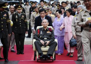 May 25, 2012, file photo, Thailand's King Bhumibol Adulyadej, center, is pushed in a wheelchair as he arrives at a rice field in Ayutthaya province, central Thailand. Thailand's Queen Sirikit, in purple, is walking at rear with Princess Sirindhorn. Thailand's Royal Palace said on Thursday, Oct. 13, 2016, that Thailand's King Bhumibol, the world's longest-reigning monarch, has died at age 88. 