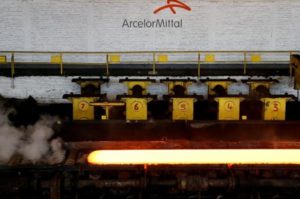 A red-hot steel plate passes through a press at the ArcelorMittal steel plant in Ghent, Belgium.