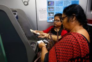 Women deposit 500 Indian rupee banknotes in a cash deposit machine in Kolkata, India, November 8, 2016. 