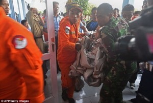 Unidentified items from flight 8501 are carroed in to an Indonesia Air Force press conference earlier today