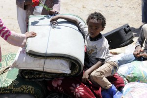  A little African asylum-seeker, living near the Sana'a International Airport, seen near their belongings as they leave the region after airstrikes of a 10-member coalition of Gulf countries in Yemeni capital Sanaa on March 26, 2015. Saudi Arabia has launched military operations in Yemen, as part of a coalition of over 10 countries in response to a direct request from the legitimate government of Yemen, against the Shiite Houthi group, which seized capital Sanaa and several provinces.