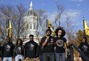 Nov. 9, 2015, file photo, Jonathan Butler, center, addresses a crowd following the announcement that University of Missouri System President Tim Wolfe would resign, in Columbia, Mo. The bullet points are blunt and direct: Blacks at the University of Missouri are harassed and threatened, the university has too few African-American faculty members, administration doesn't seem to care, and all of that needs to change. A set of demands addressing those concerns is strikingly similar to demands made in 1969. But this time, it appears the university is listening. 