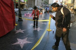 A man takes a photo of the vandalized star for Republican presidential candidate Donald Trump on the Hollywood Walk of Fame, Wednesday, Oct. 26, 2016, in Los Angeles. 