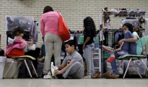 Central American migrants newly released after processing by the U.S. Customs and Border Patrol are fitted for shoes at the Sacred Heart Community Center in the Rio Grande Valley border city of McAllen, Texas, Sunday, Nov. 13, 2016. President-elect Donald Trump is starting to sound a lot more like President Barack Obama on his stance on immigration and easing his pledge to build a wall across the Mexican border.